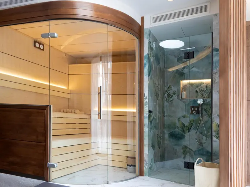 Espace bien-être avec sauna en bois et douche à l'italienne.