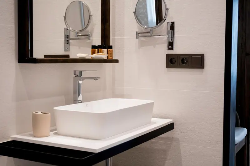Un lavabo blanc et un robinet chromé dans une salle de bain moderne.