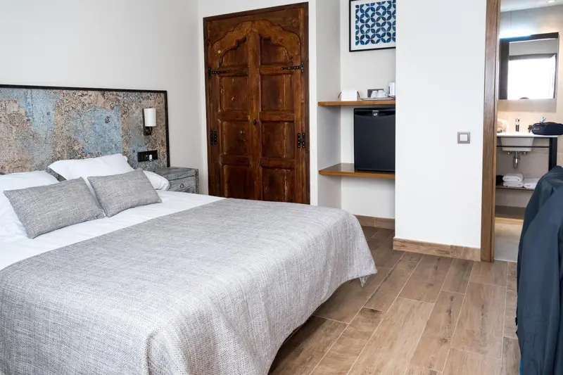 Une chambre lumineuse avec un grand lit et une décoration murale.
