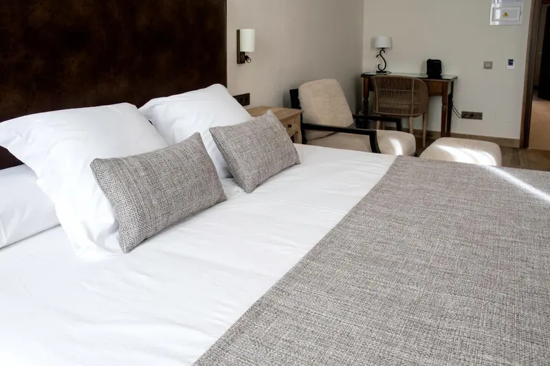Un lit confortable avec des oreillers moelleux dans une chambre lumineuse.