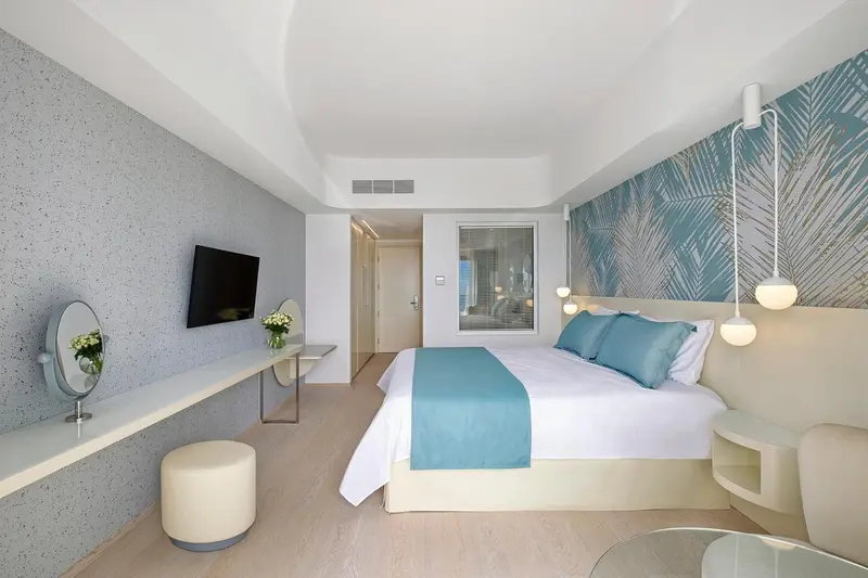 Chambre lumineuse avec un grand lit et une décoration moderne.