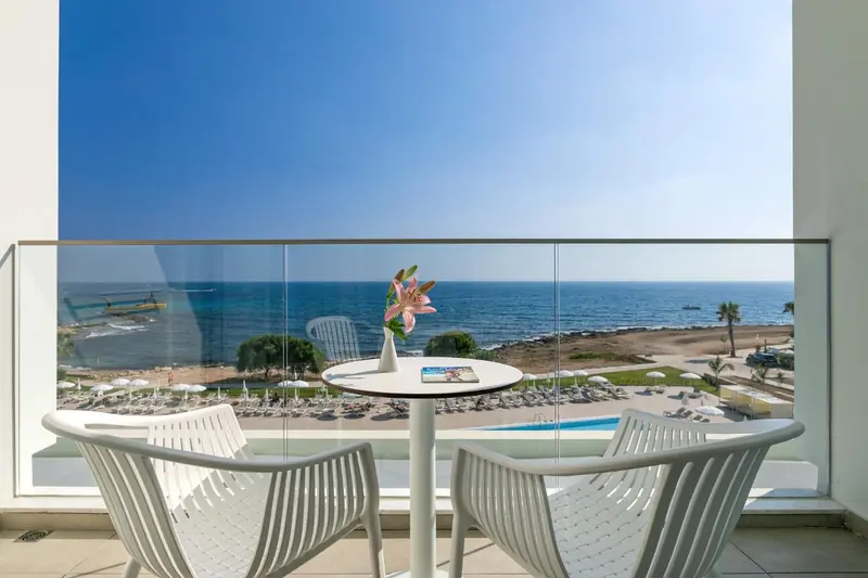 Vue sur la mer depuis une terrasse avec mobilier d'extérieur.