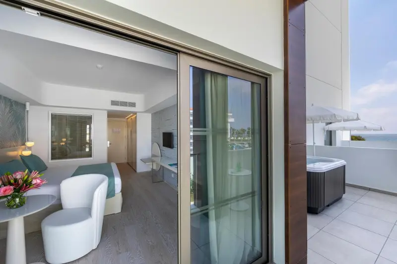 Une chambre lumineuse s'ouvre sur une terrasse avec jacuzzi.