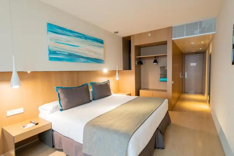 Une chambre lumineuse avec un grand lit et une décoration moderne.