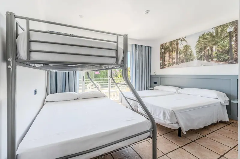 Une chambre avec un lit superposé et un lit double.
