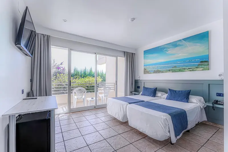 Une chambre lumineuse avec un grand lit et un accès à un balcon.