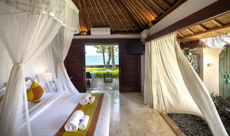 Une chambre avec un lit à baldaquin donnant sur une vue sur la mer.