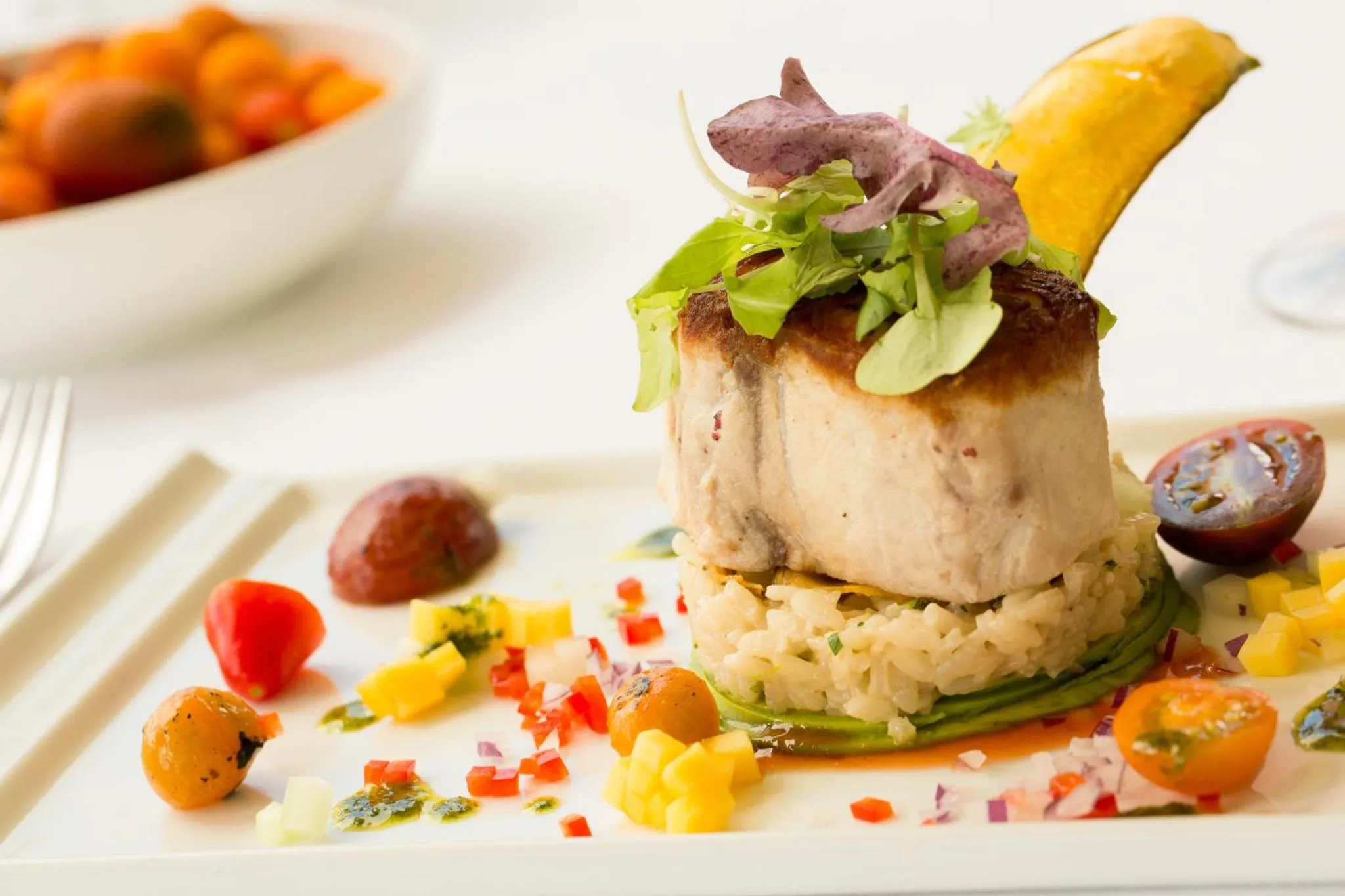 Assiette raffinée de poisson grillé accompagné de riz et de légumes.