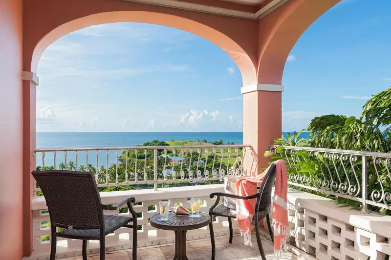 Terrasse avec deux fauteuils et une table basse donnant sur la mer.