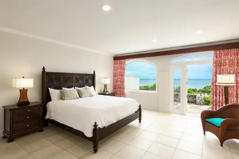 Une chambre lumineuse avec un grand lit et une vue sur la mer.