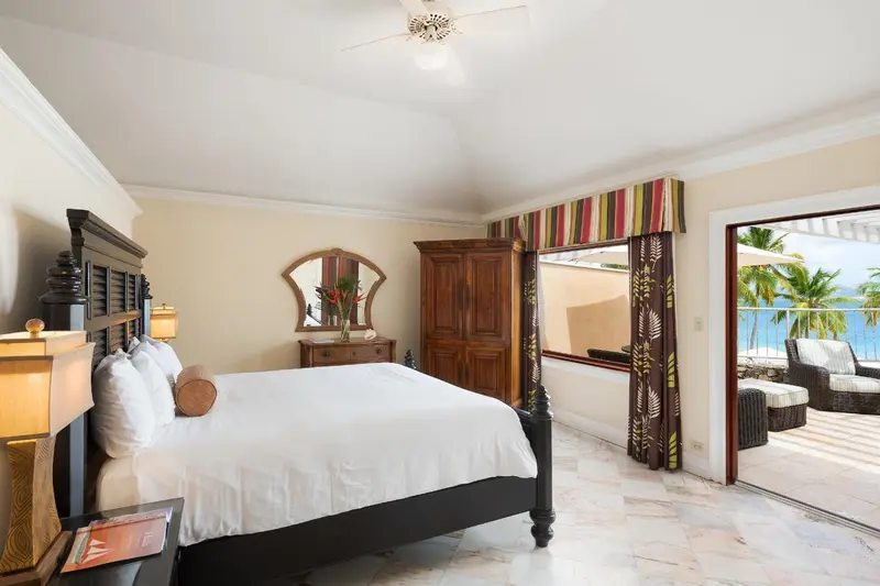 Une chambre lumineuse avec un grand lit et un accès à une terrasse.