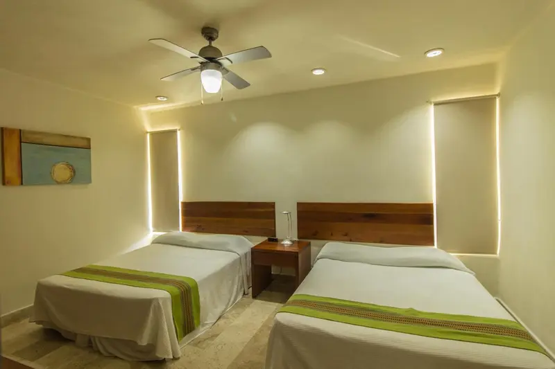Une chambre lumineuse avec deux lits simples et une décoration sobre.