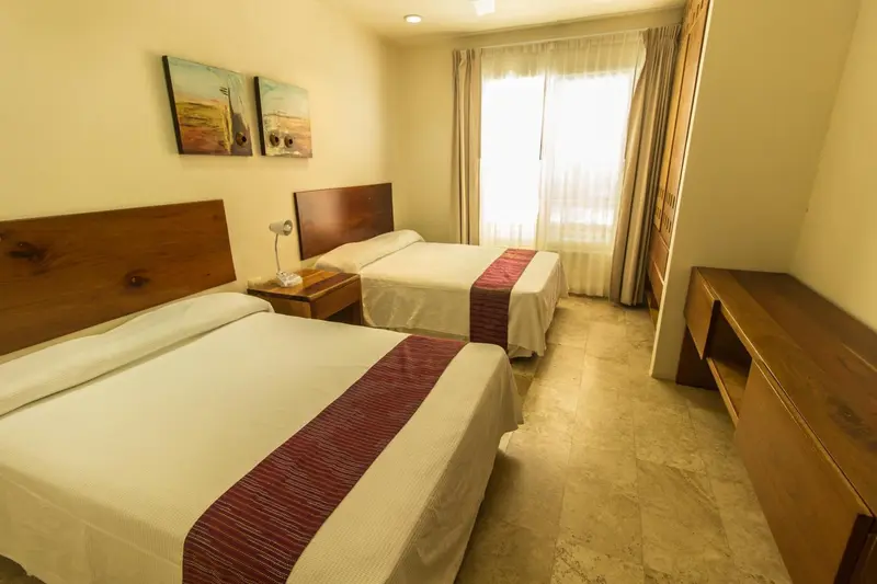 Une chambre lumineuse avec deux lits simples et une décoration sobre.