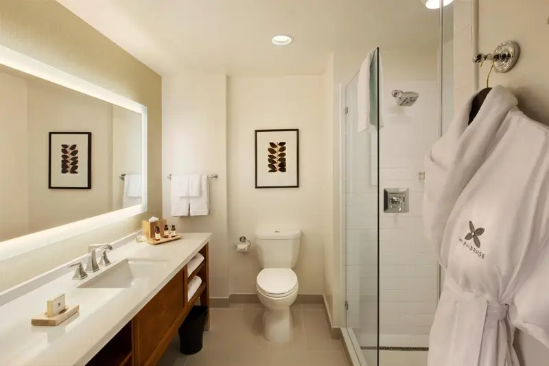 Une salle de bain lumineuse avec douche vitrée et vasque double.
