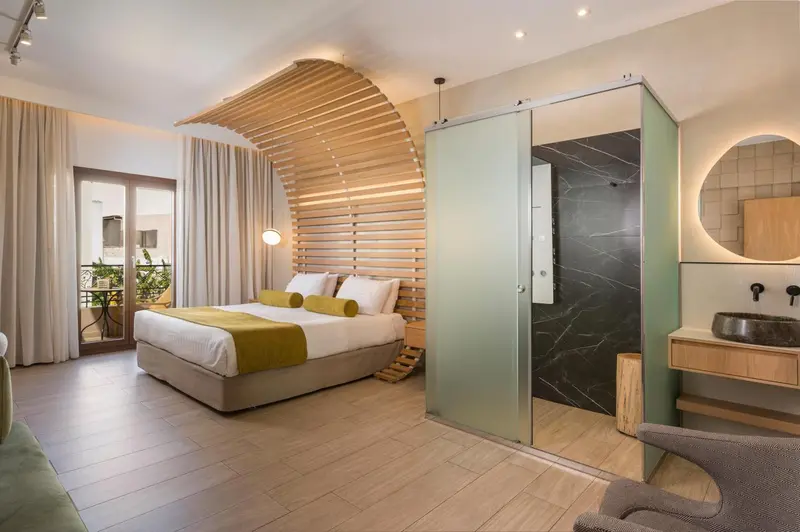 Une chambre lumineuse avec un grand lit et un espace détente.