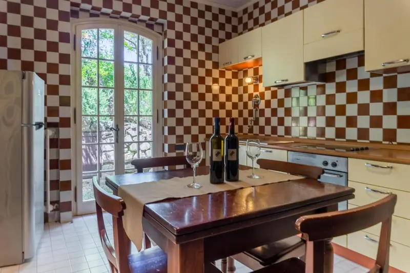 Une cuisine lumineuse avec une table et des chaises près d'une fenêtre.