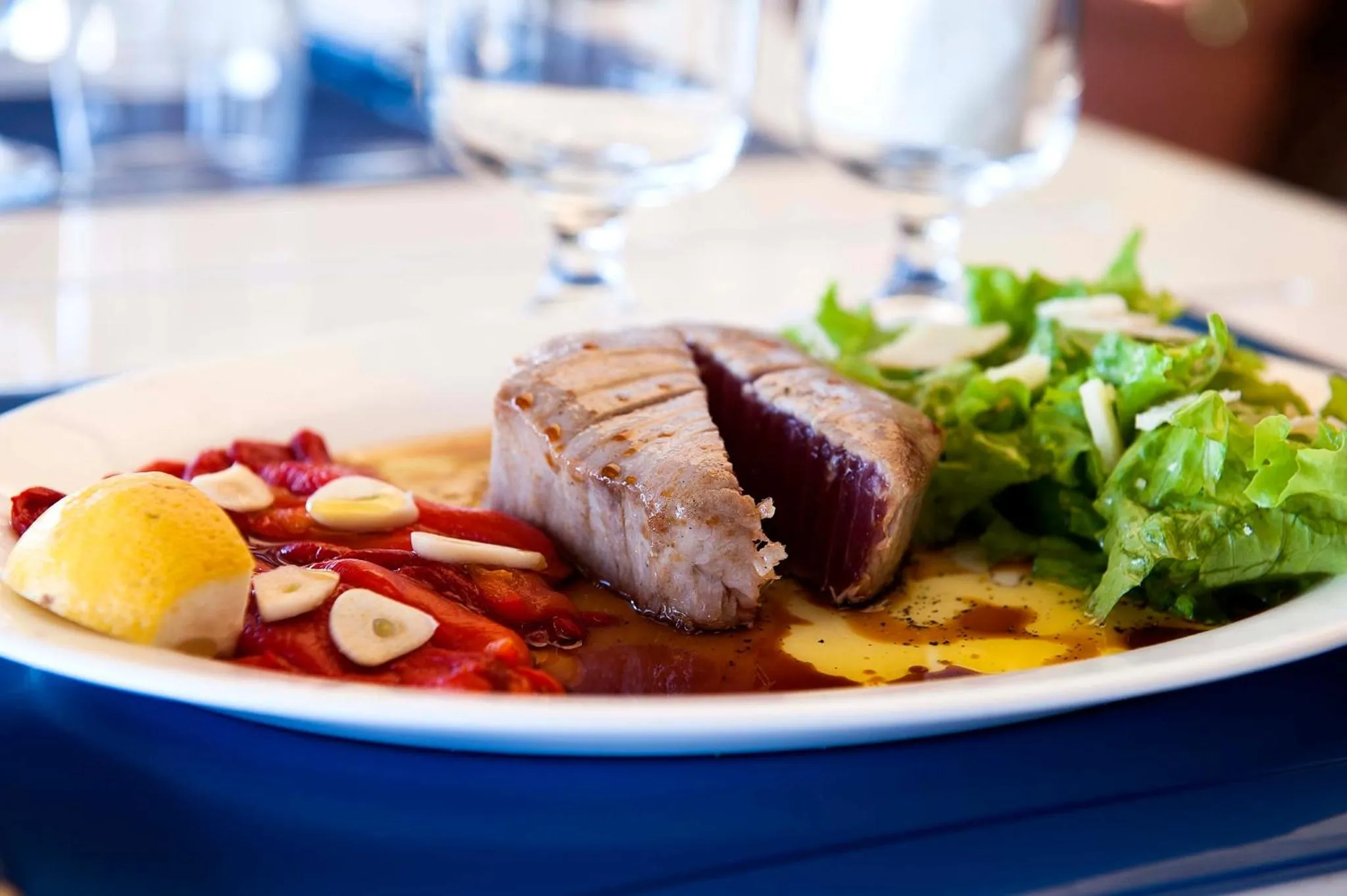 Assiette de poisson grillé accompagné de légumes et d'une sauce.