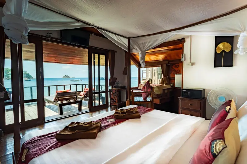 Une chambre avec un lit decoré donnant sur une vue mer.