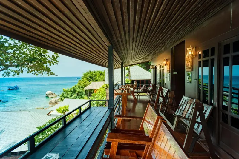 Terrasse en bois avec mobilier de jardin donnant sur la mer.