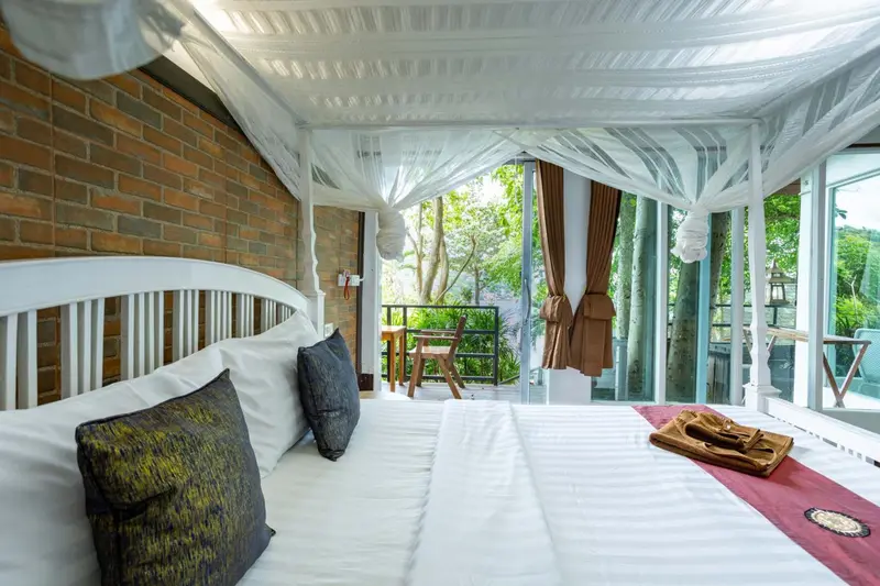 Un lit recouvert de draps blancs et d'oreillers dans une chambre lumineuse.