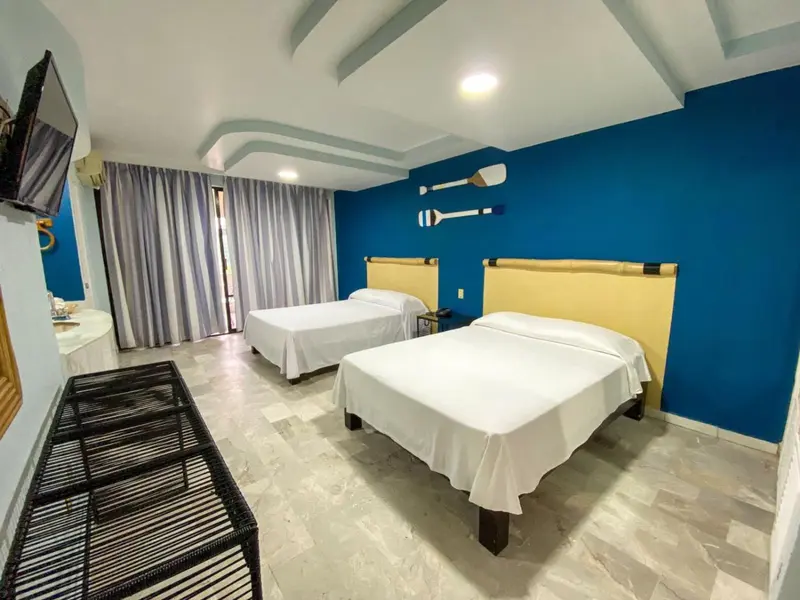 Chambre lumineuse avec deux lits simples et décoration marine.