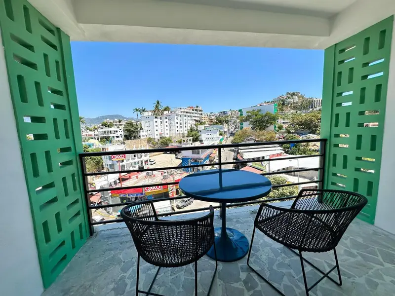 Une terrasse avec une table et des chaises offre une vue sur la ville et la mer.