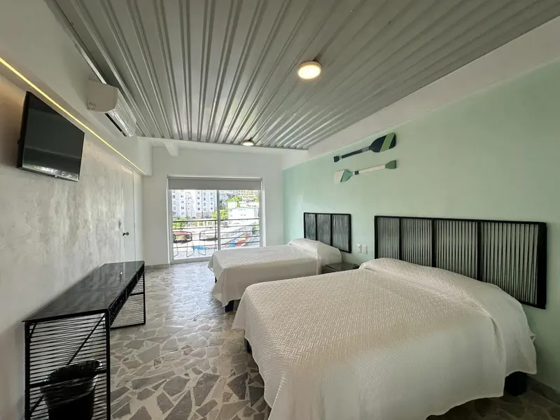 Une chambre lumineuse avec deux lits simples et une décoration minimaliste.