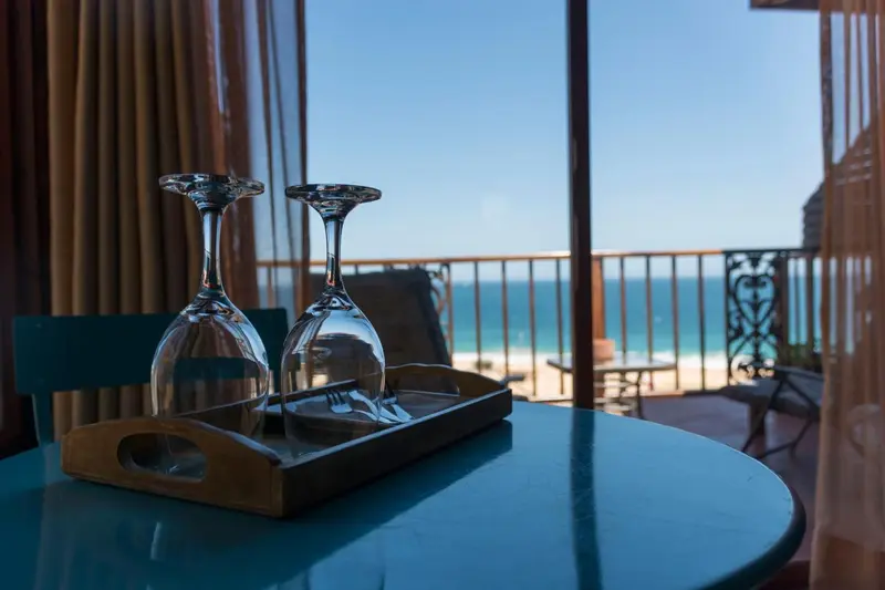 Deux verres à vin sur une table basse avec vue sur la mer.