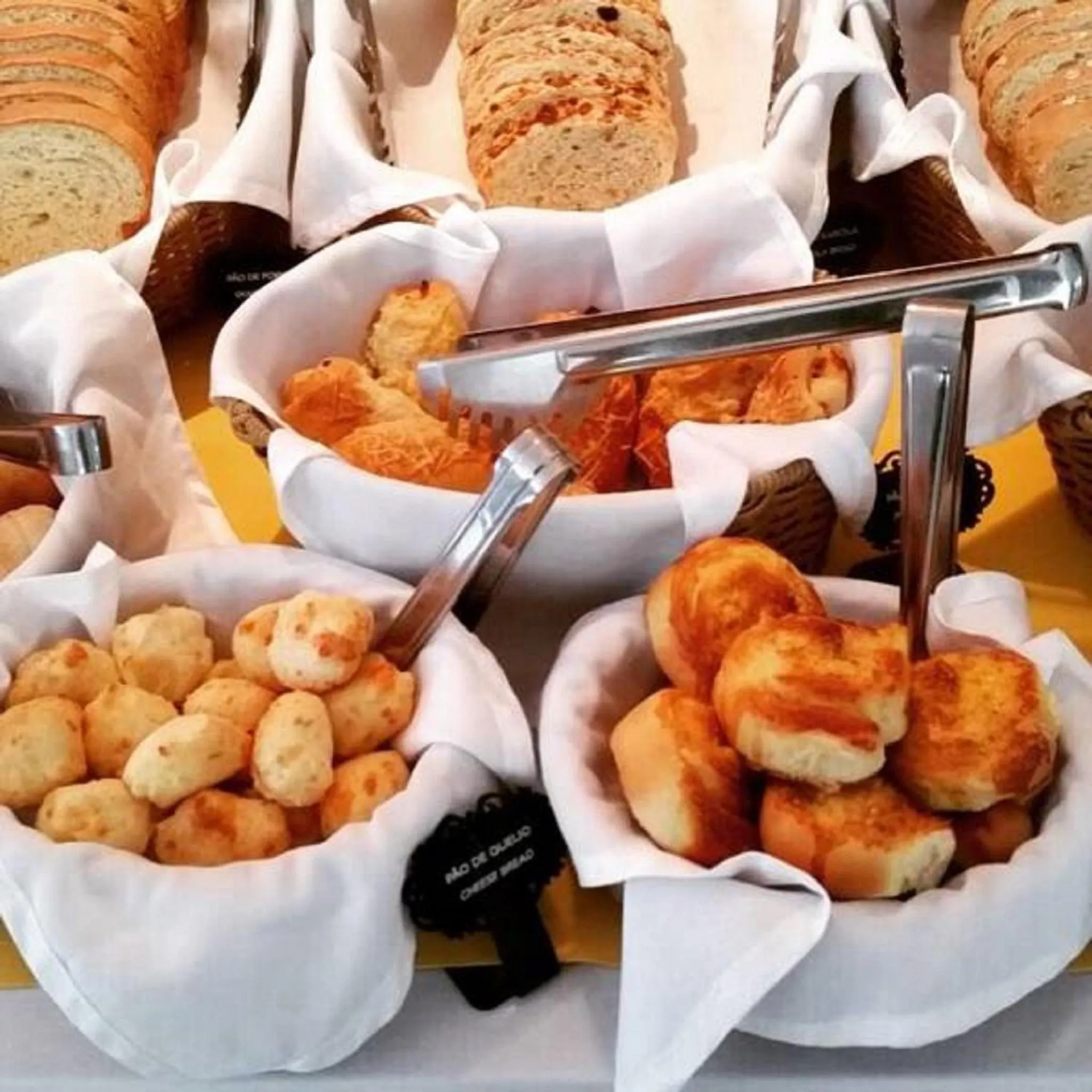 Assortiment de pains et de viennoiseries présentés sur un buffet.