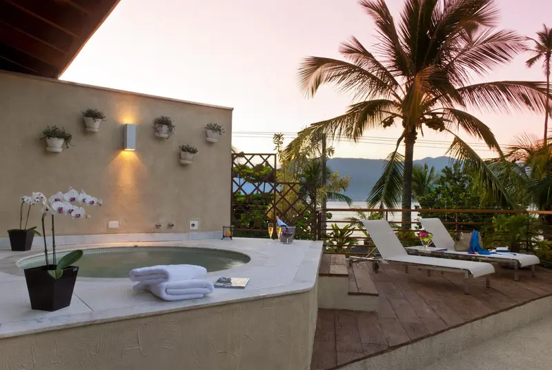 Un jacuzzi sur une terrasse avec des chaises longues et une vue sur la mer.