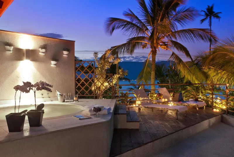 Terrasse avec jacuzzi et mobilier de détente au crépuscule.