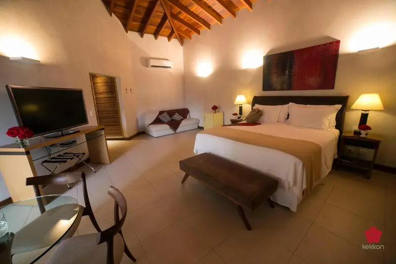 Une chambre lumineuse avec un lit et un espace salon.