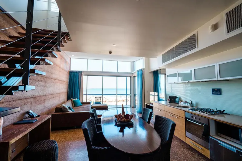 Espace de vie lumineux avec cuisine équipée et vue sur la mer.