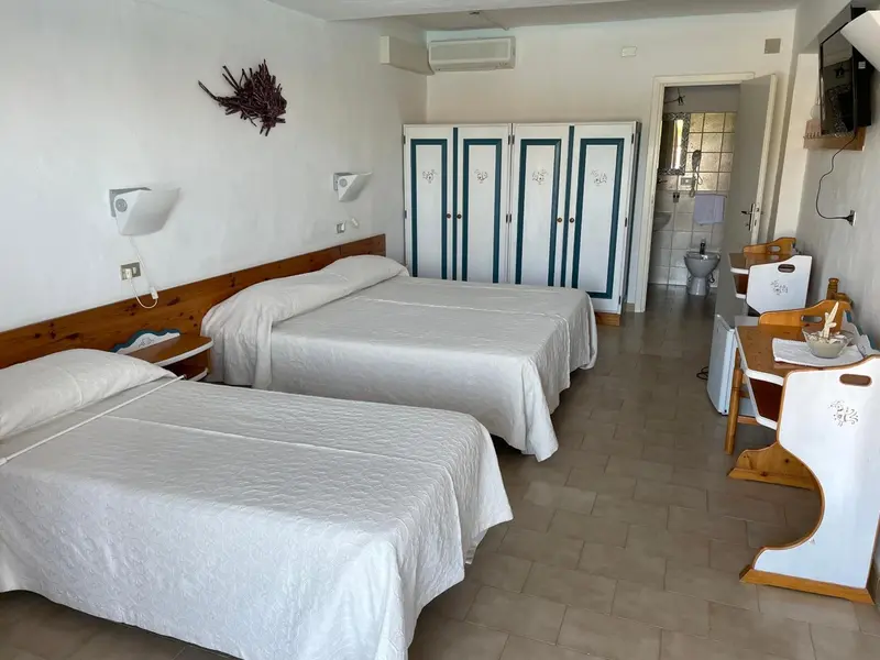 Une chambre lumineuse avec deux lits simples et une commode décorative.