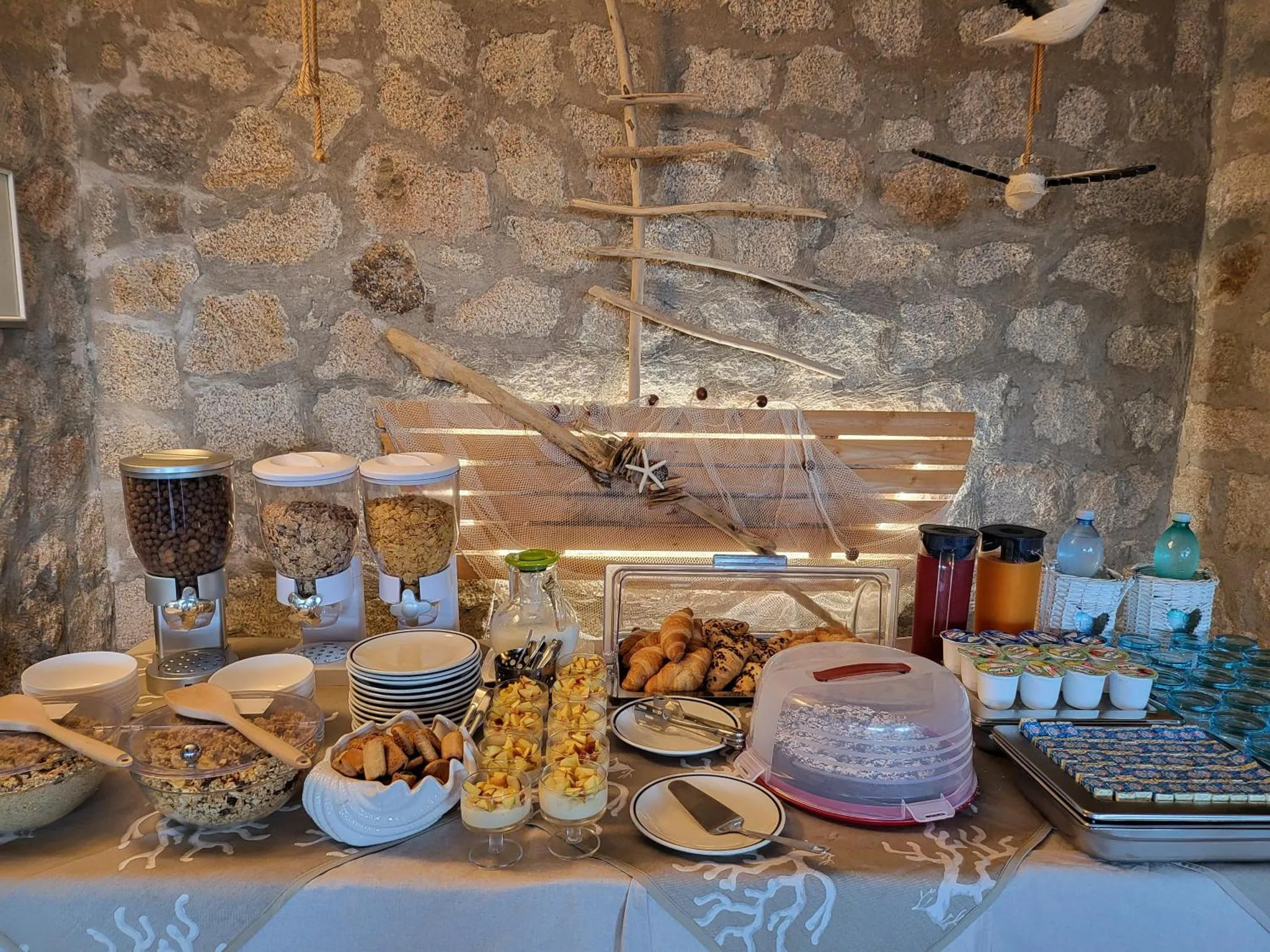 Un buffet propose des viennoiseries, des céréales et des fruits.