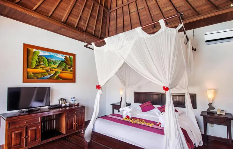 Une chambre avec un grand lit à baldaquin et une décoration florale.