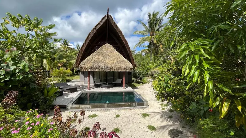 Une villa sur pilotis avec une petite piscine privée et une végétation luxuriante.