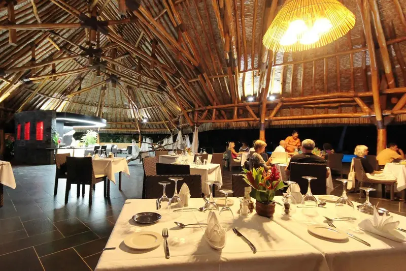 Une salle de restaurant lumineuse avec des tables dressées et des clients attablés.