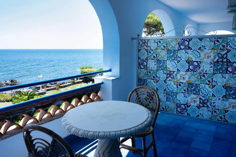 Une terrasse avec une table ronde et une vue sur la mer.