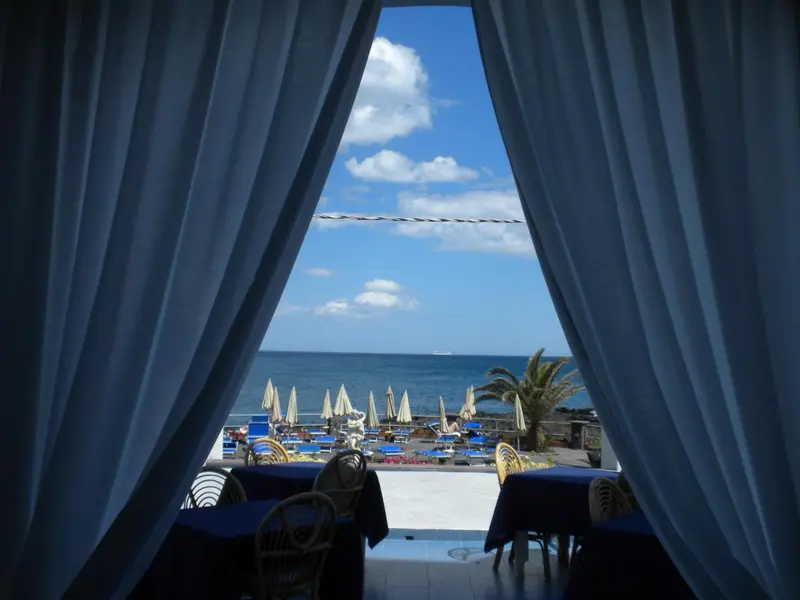 Vue sur la mer depuis une ouverture ombragée.