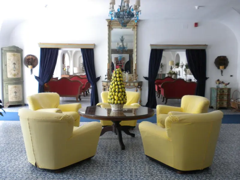 Un salon lumineux avec des fauteuils jaunes et des canapés rouges.
