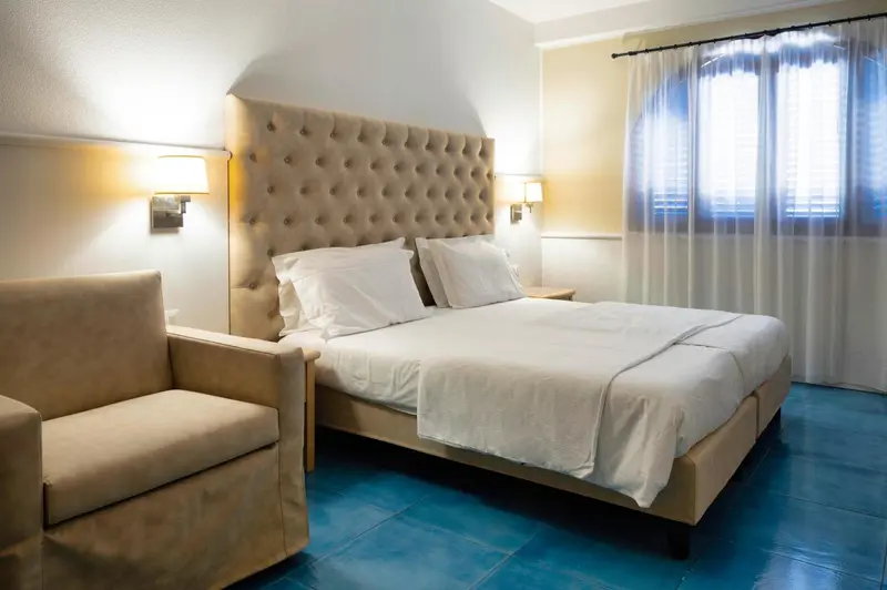 Une chambre lumineuse avec un grand lit et un coin salon.