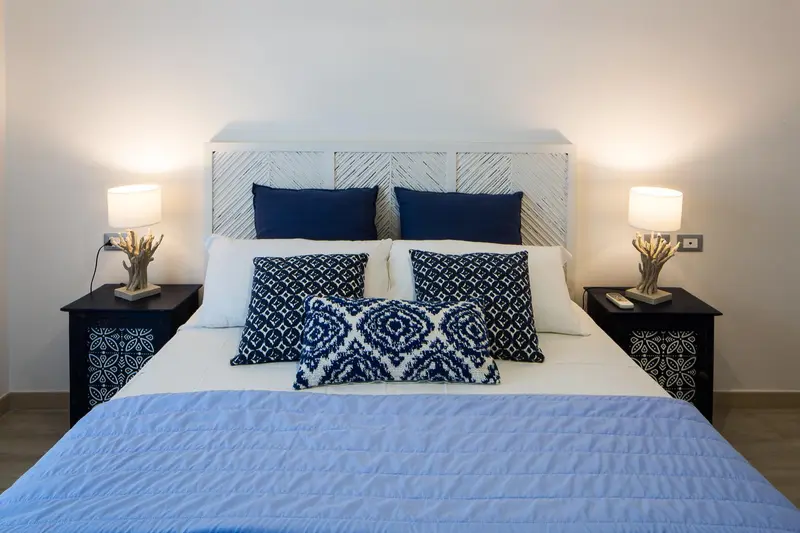 Un lit double est dispose dans une chambre aux tons bleus et blancs.