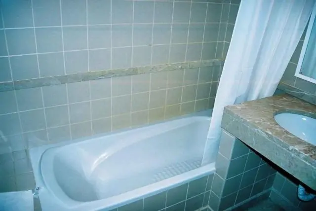 Une baignoire blanche dans une salle de bain carrelée.