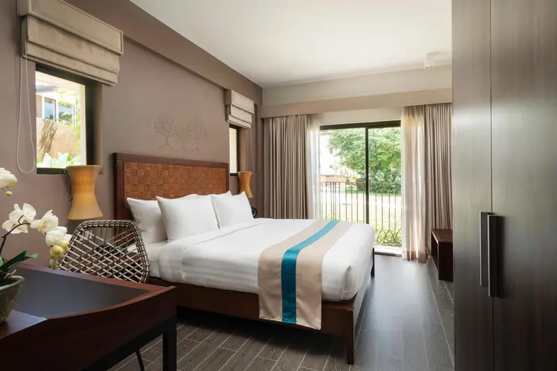 Une chambre lumineuse avec un grand lit et un accès à une terrasse.