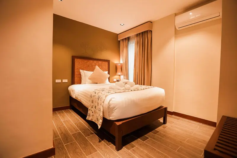 Une chambre lumineuse avec un grand lit recouvert de coussins.