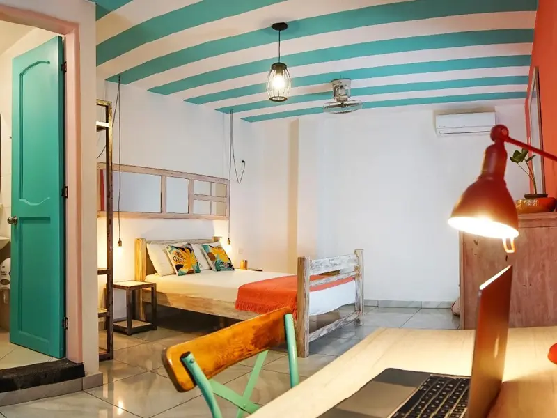 Une chambre lumineuse avec un lit et un bureau en bois.