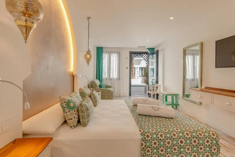 Chambre lumineuse avec un lit confortable et un coin salon.