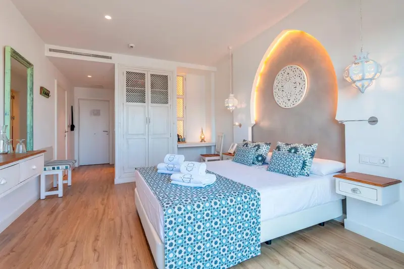 Chambre lumineuse avec un grand lit et une décoration soignée.