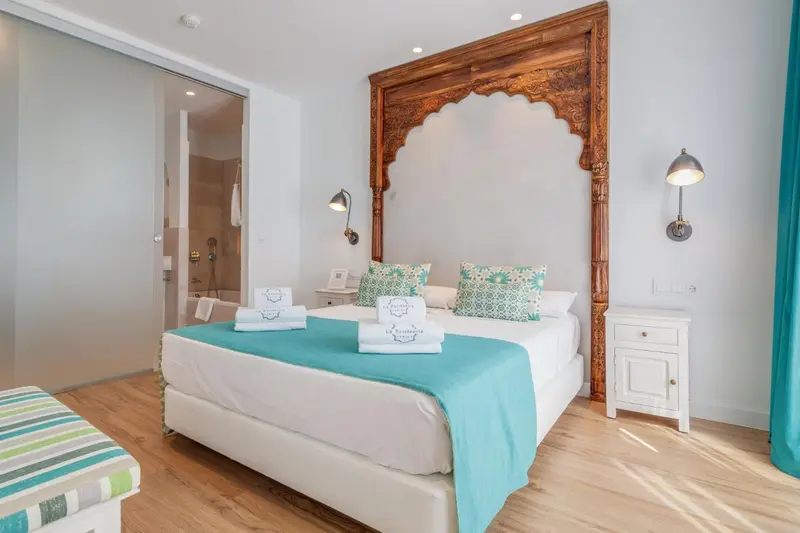 Une chambre lumineuse avec un grand lit et une décoration soignée.